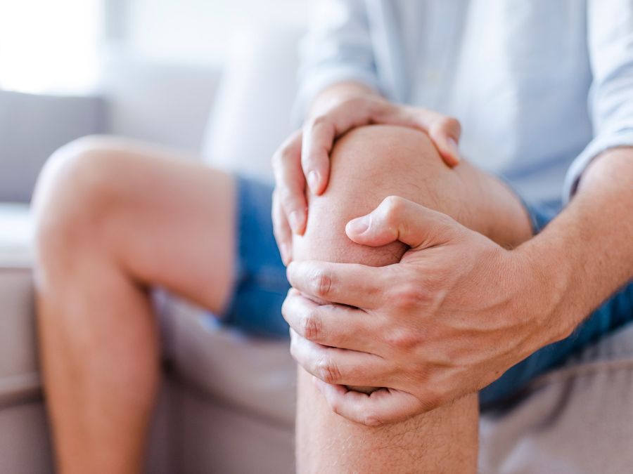 Persona che si tocca il ginocchio per il dolore